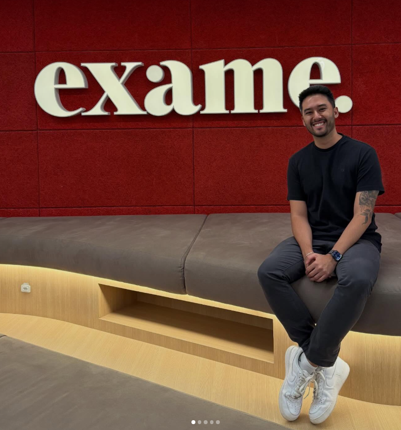 Rafael Kenji em frente ao letreiro da revista Exame